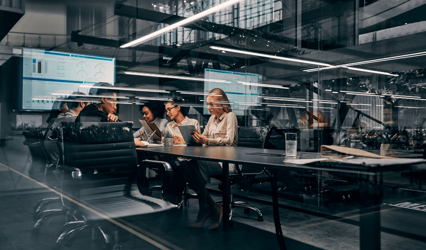 Team collaborating in modern glass-walled office
