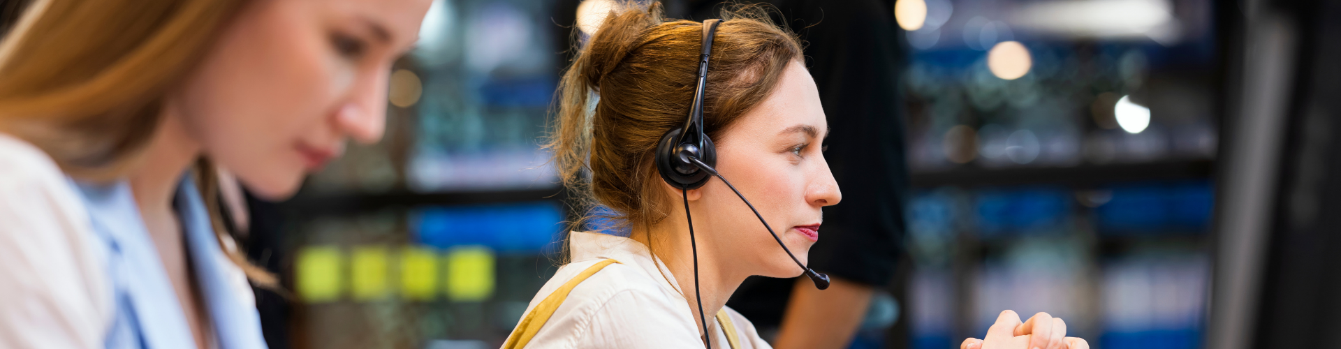 Customer support agent wearing a headset at a computer workstation