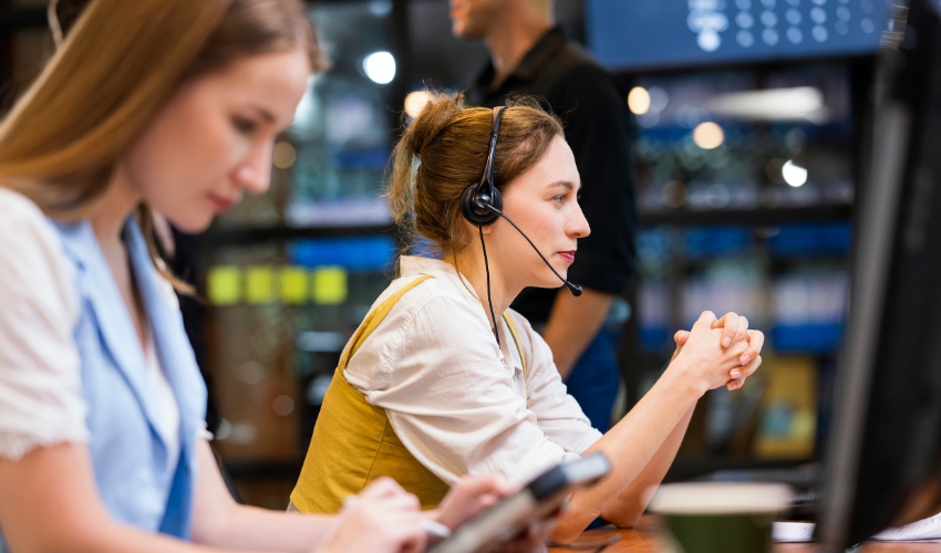 Customer support agent wearing a headset at a computer workstation