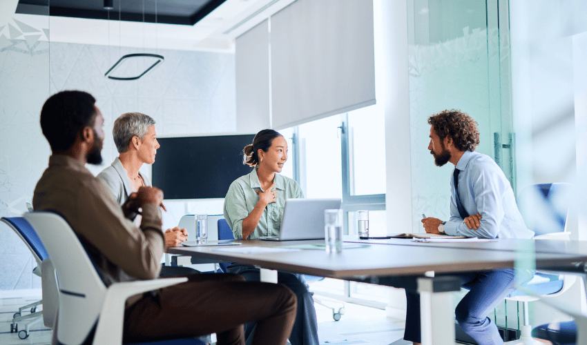 Group of colleagues chatting in boardroom
