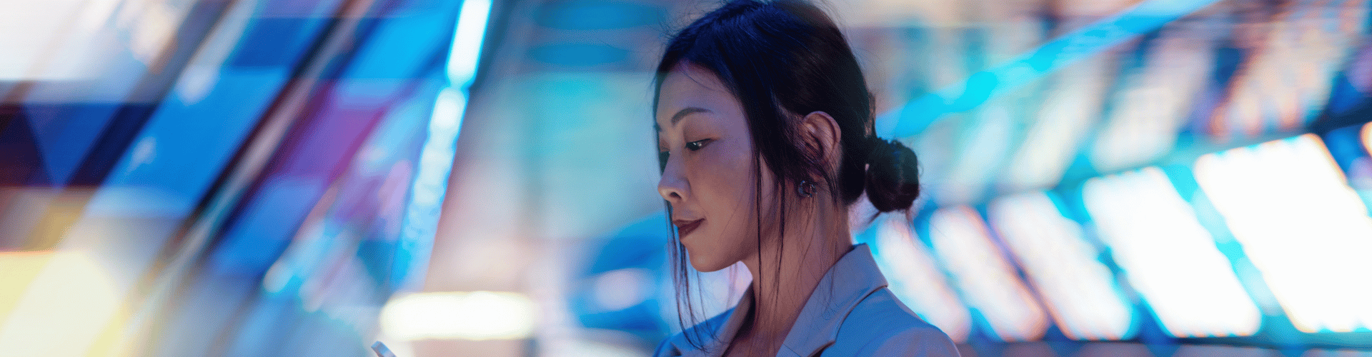 Businesswoman using a smartphone on a futuristic lit walkway
