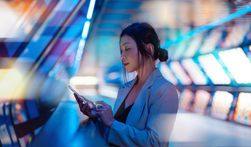 Businesswoman using a smartphone on a futuristic lit walkway